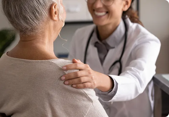 Doctor reassuring a senior patient during a clinic consultation